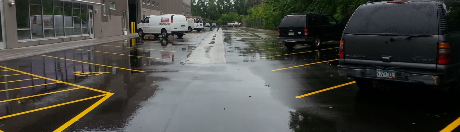 Newly paved parking lot with vehicles and building