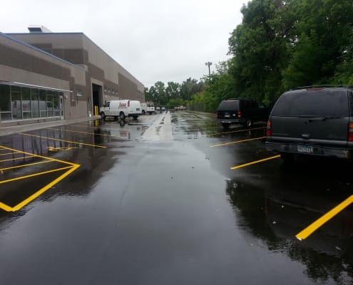 Newly paved parking lot with vehicles and building